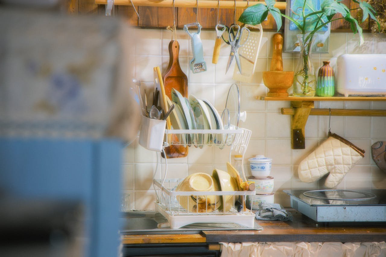 Warm vintage kitchen scene with dishes, utensils, and plants creating a cozy atmosphere.